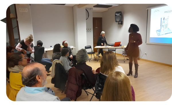 Niurys Núñez impartiendo una charla en una sala de conferencias, interactuando con su audiencia mientras una presentación se proyecta en la pantalla.