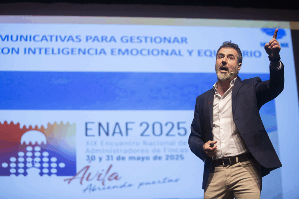 Fotografía de Zacarías Romero durante su conferencia en el XIX Encuentro Nacional de Administradores de Fincas (ENAF 2025) en Ávila, gesticulando con energía frente a una pantalla con el tema de inteligencia emocional y equilibrio.