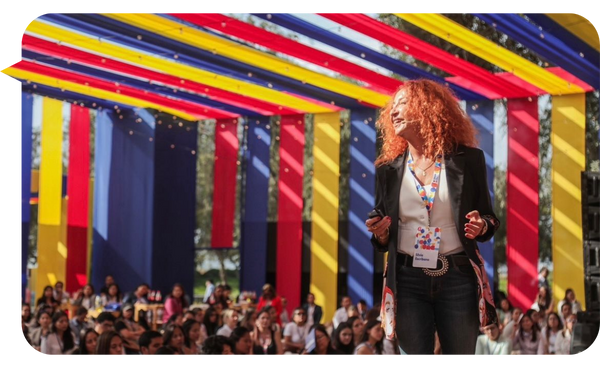 Silvia Escribano hablando en un evento al aire libre con decoraciones coloridas.