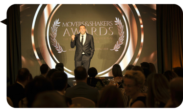 Nacho Barraquer en un escenario dando un discurso durante la ceremonia de los premios Movers & Shakers, con un público sentado al frente.